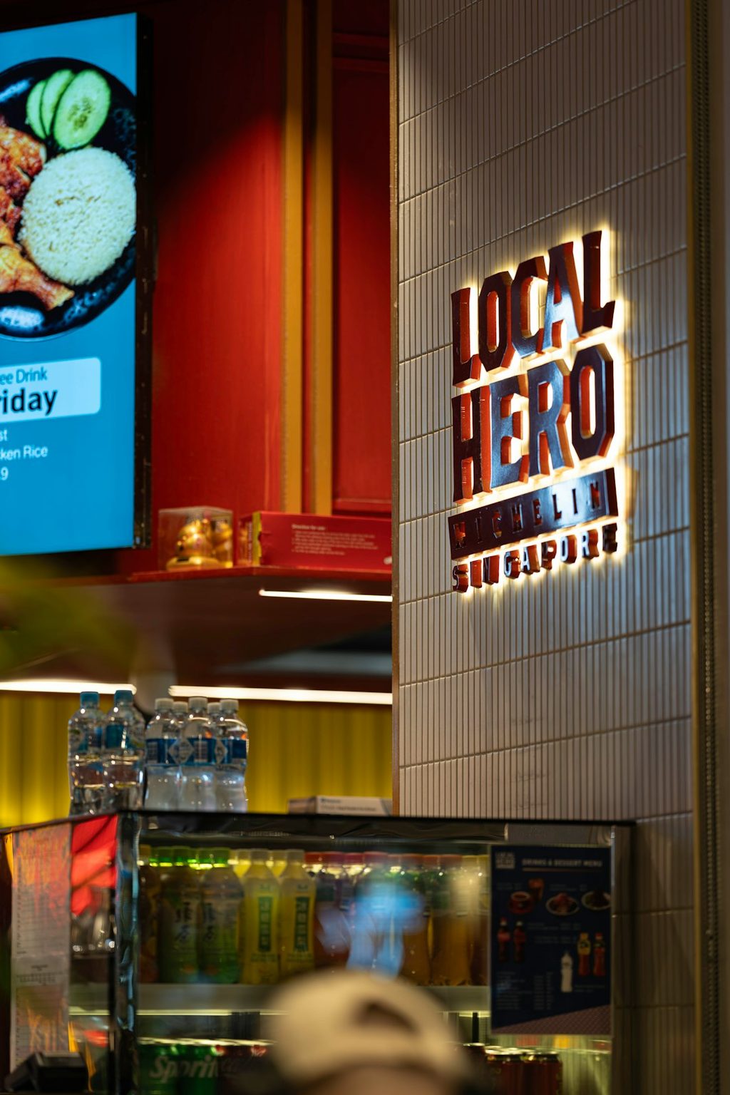 Tanda restoran Local Hero Singapore dengan desain modern dan warna-warna cerah.