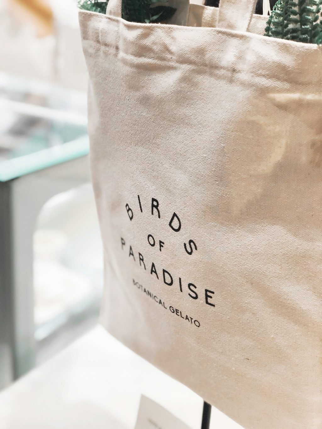 tas kain putih dengan tulisan 'Birds of Paradise' dan logo Botanical Delrayo