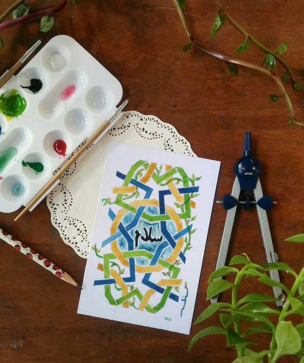 Ilustrasi tulisan Arab di atas kertas putih yang menggambarkan inspirasi tata letak notecard Lebaran bernuansa artistik.