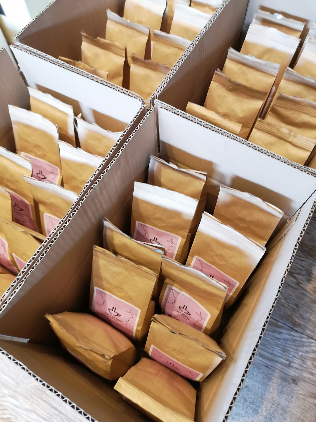 Kotak berisi banyak kemasan coklat muda yang menunjukkan peluang penempatan QR code pada box dan label untuk mendorong repeat order