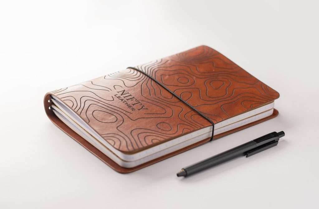 Notebook with wooden cover and topography design, suitable for office or personal use.