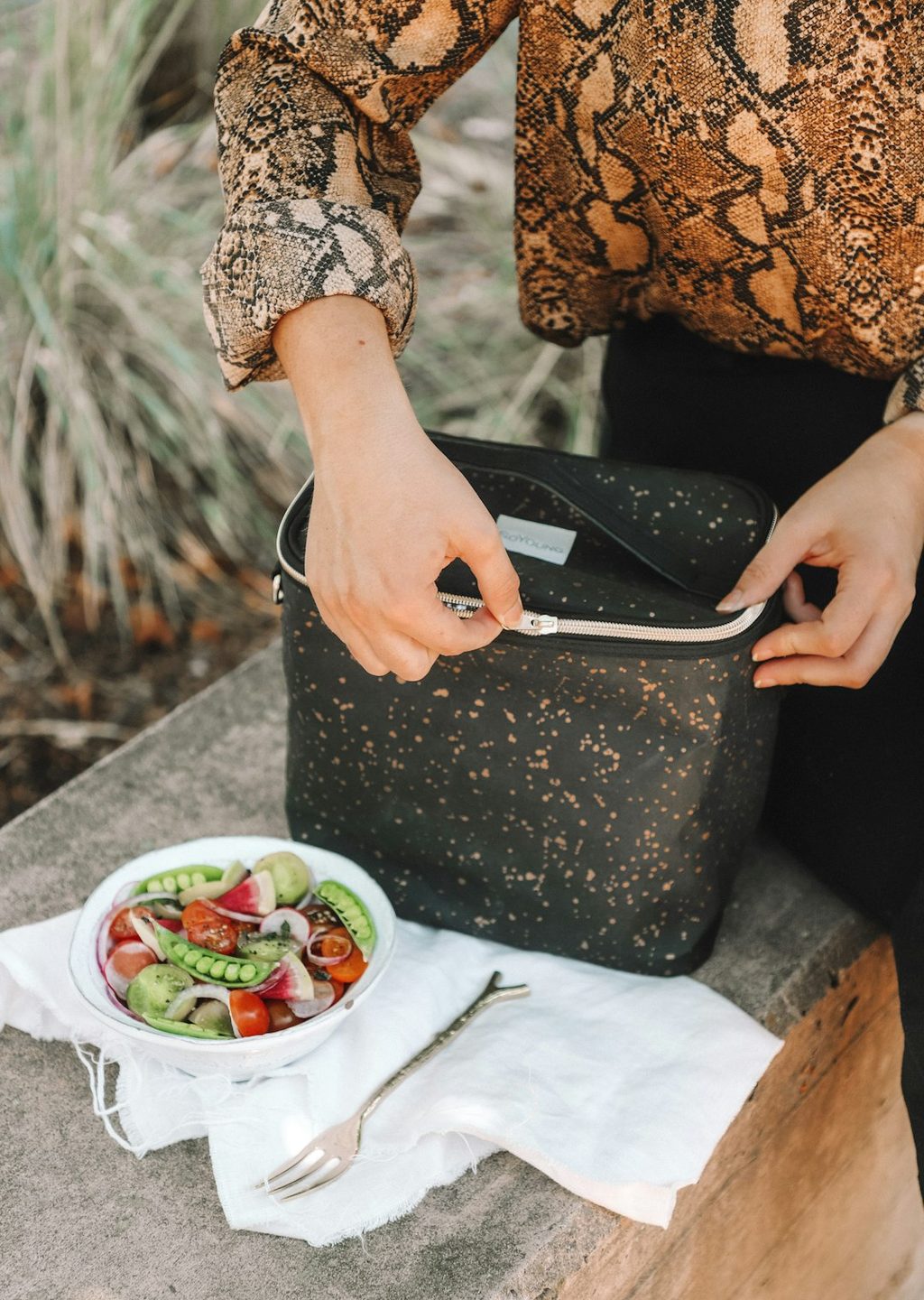 Seorang wanita memegang tas kain berulang guna dengan makanan di dalamnya.