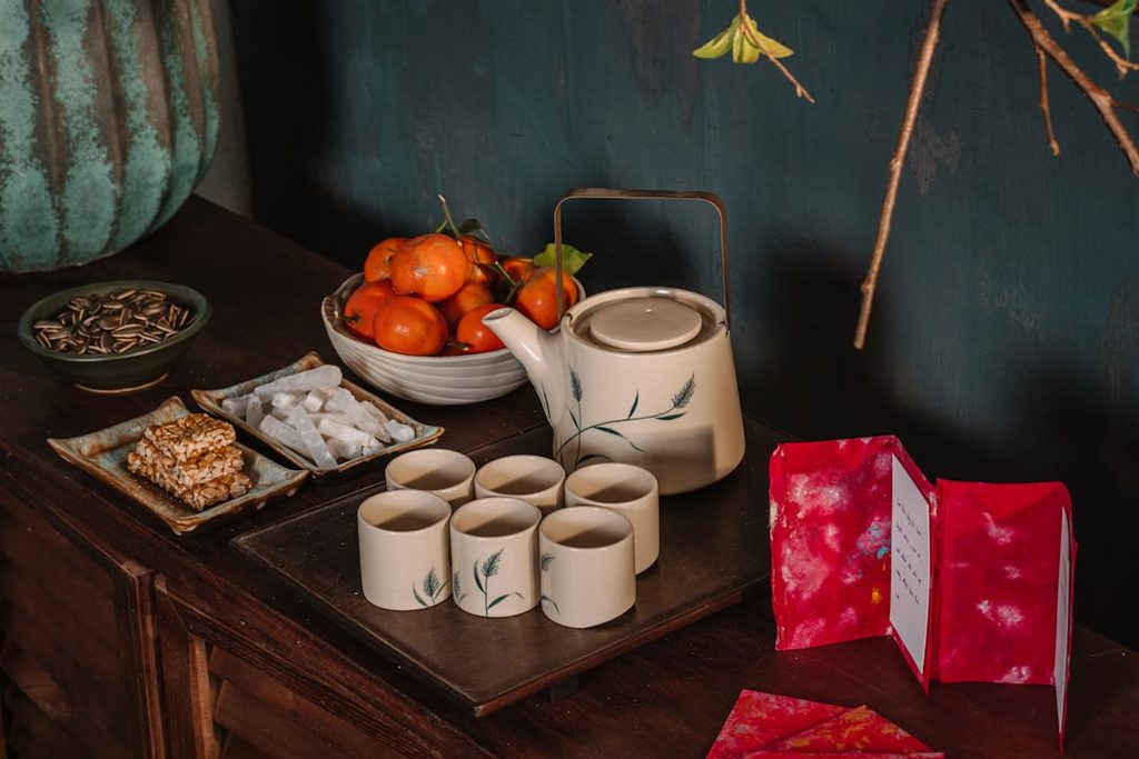 Peralatan teh elegan dengan kemasan hadiah unik di meja kayu.