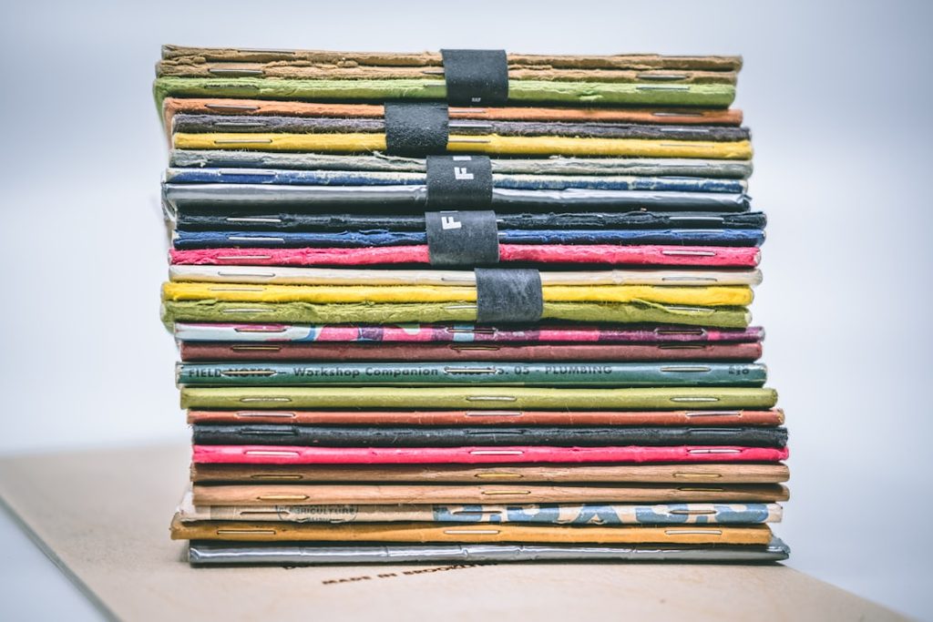Stack of colorful printed materials wrapped in black tape, representing ready-to-distribute flyer batches for business promotions and events.