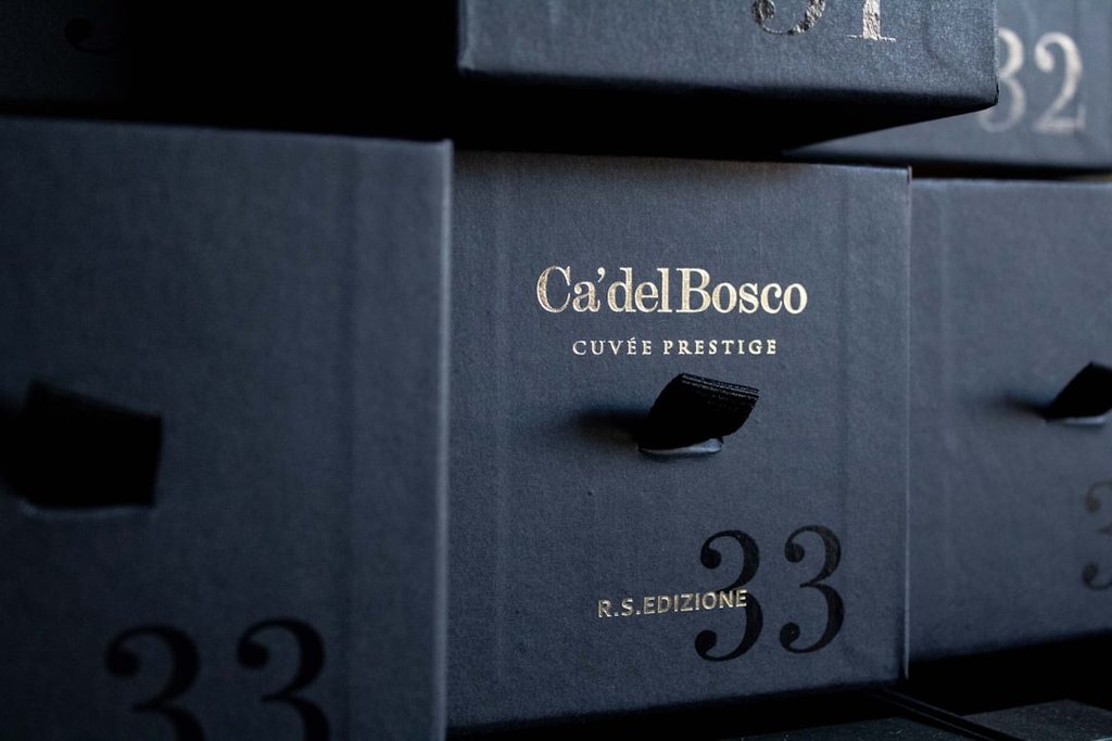 Gambar kotak kemasan premium dengan tulisan 'Ca'del Bosco Cuvée Prestige' dan nomor 33.