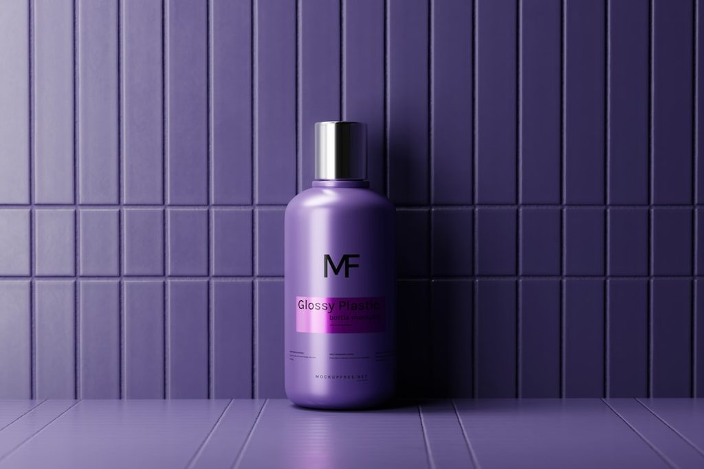Botol kosmetik warna ungu dengan logo MF dan tulisan Glossy Finish di depan dinding panel biru muda