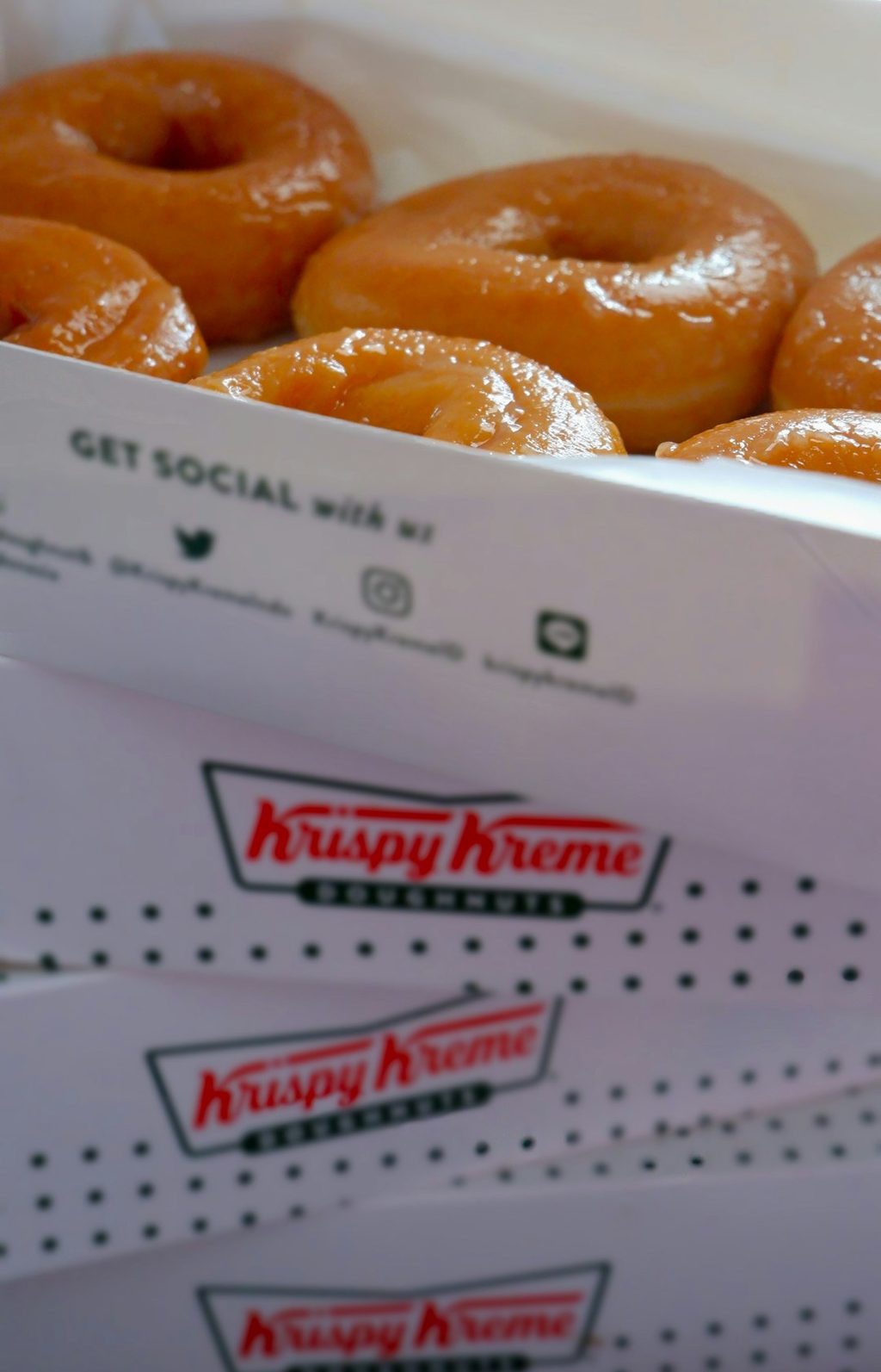 Krispy Kreme donuts arranged neatly in a branded box.
