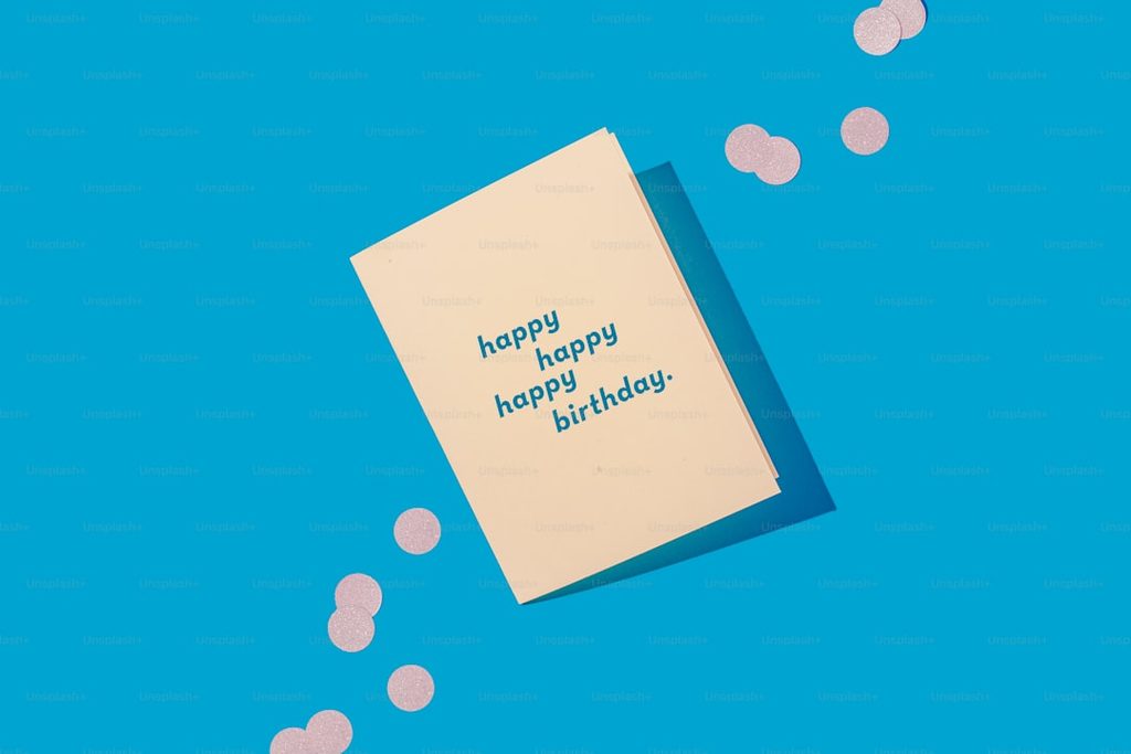 Kartu uang dengan ucapan 'Happy Birthday' di depan latar biru.