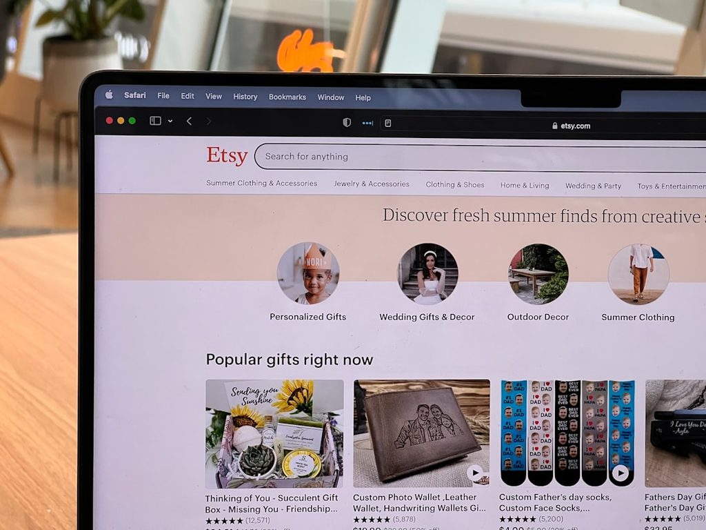 Laptop displaying Etsy website with gift options and categories.