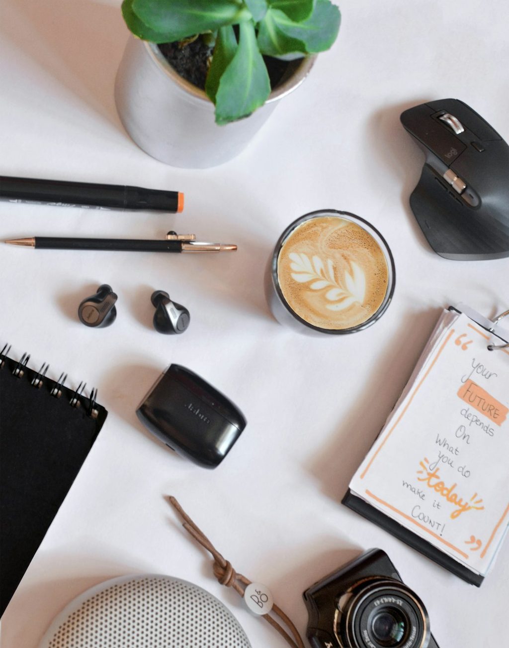 Workspace setup dengan kopi, kamera, dan stationery yang mendukung citra brand profesional