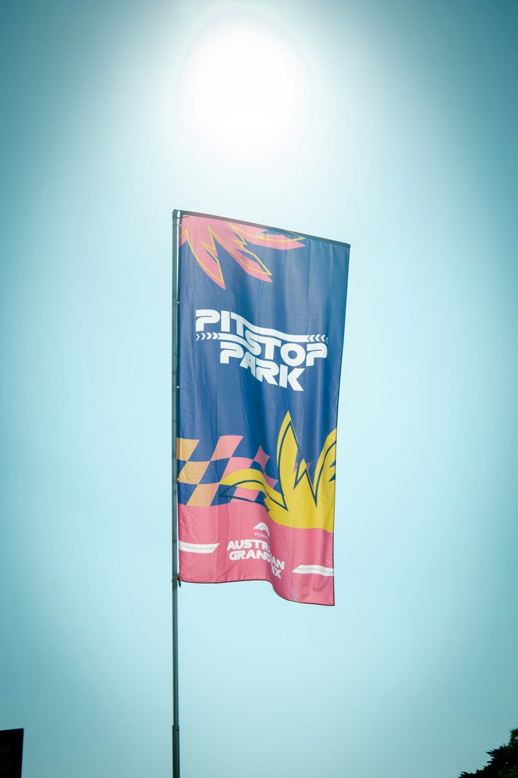 Bendera bertuliskan 'Pit Stop Park' dengan desain grafis modern