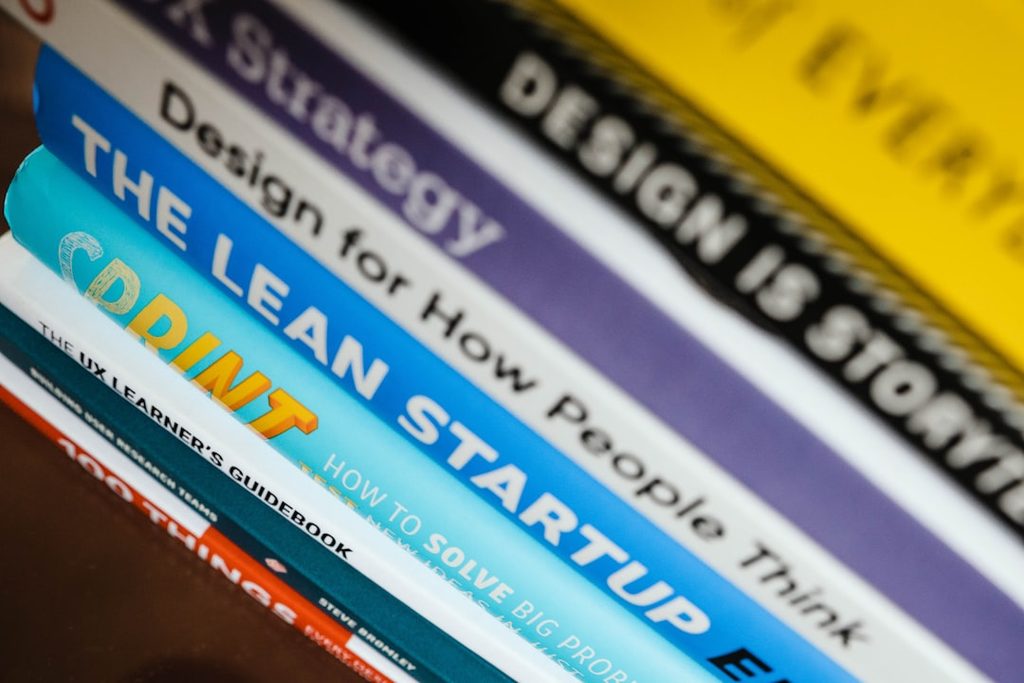 Tumpukan buku bisnis dan desain sebagai ilustrasi studi kasus brand yang meningkatkan repeat order lewat pengalaman visual yang lebih rapi.