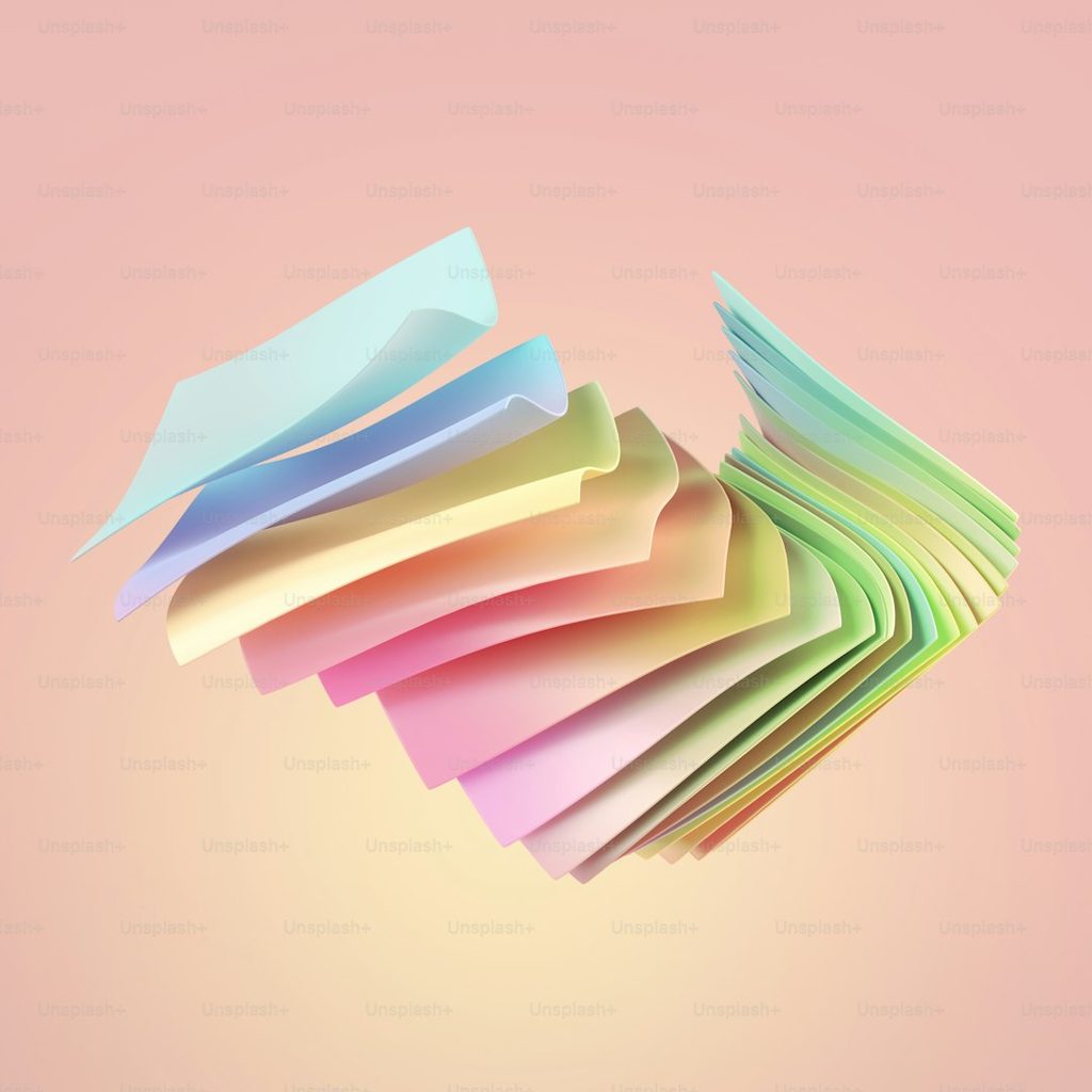 Pile of colorful papers arranged in a fan shape on a pink background, illustrating how full-color printed flyers create stronger visual impact.