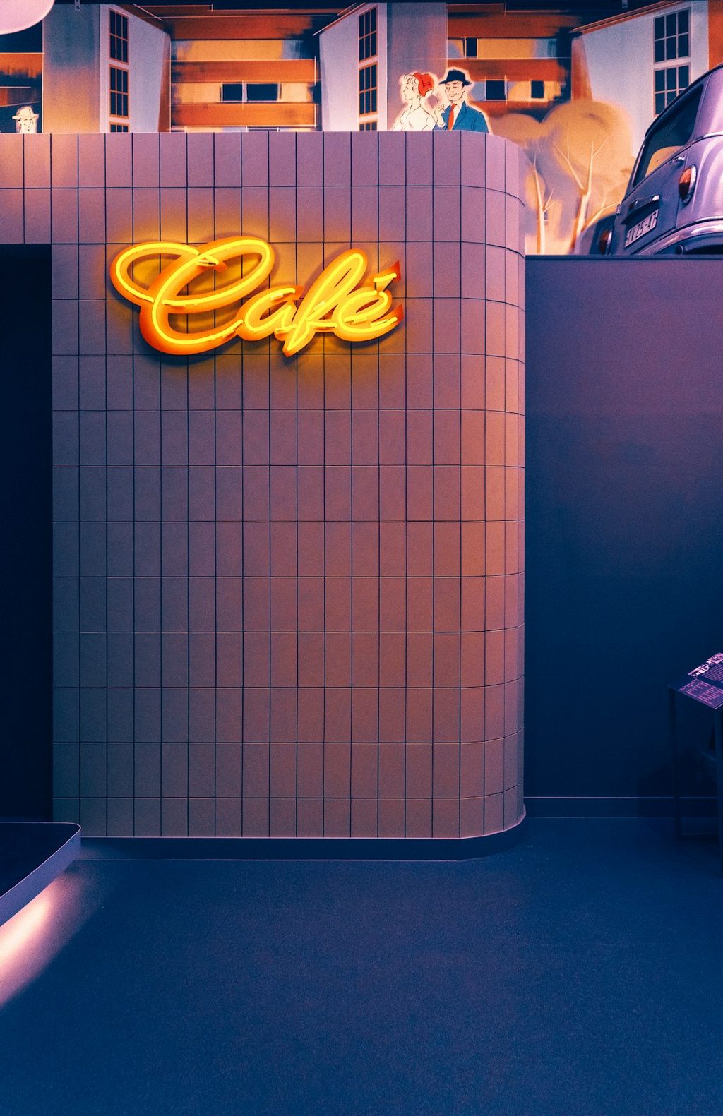 Tampak depan cafe dengan neon sign 'Cafe' yang menonjol