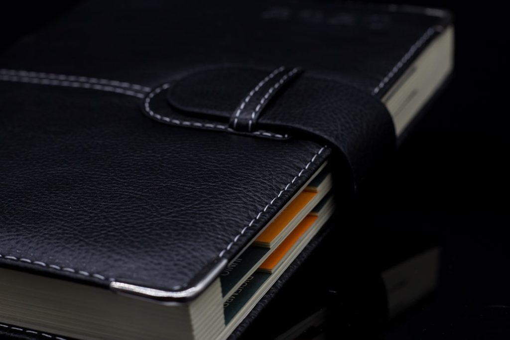 Buku menu dengan sampul kulit hitam premium yang menggunakan tipografi elegan di dalamnya