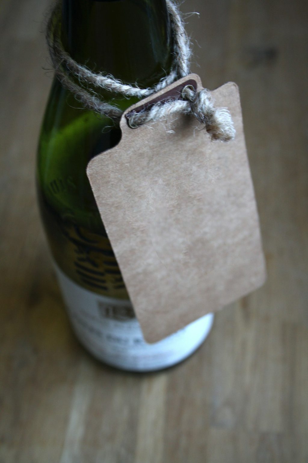 Hangtag kraft terikat pada botol minuman, ideal untuk promosi.