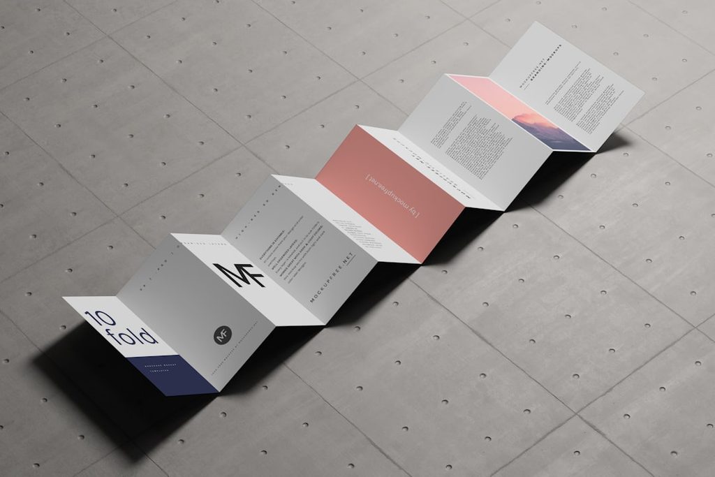 Brosur lipat 4 modern dengan desain minimalis di permukaan beton.