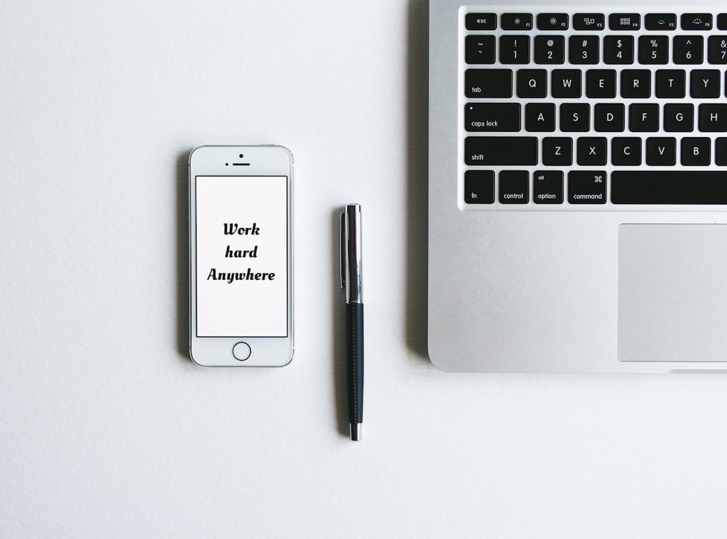 Smartphone menampilkan pesan motivasi di depan laptop, menggambarkan pentingnya teks yang cepat terbaca pada media promosi.