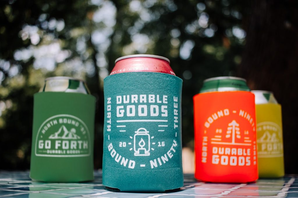 Tiga kooldr dengan desain Durable Goods untuk can drink, warna hijau, biru, dan merah.