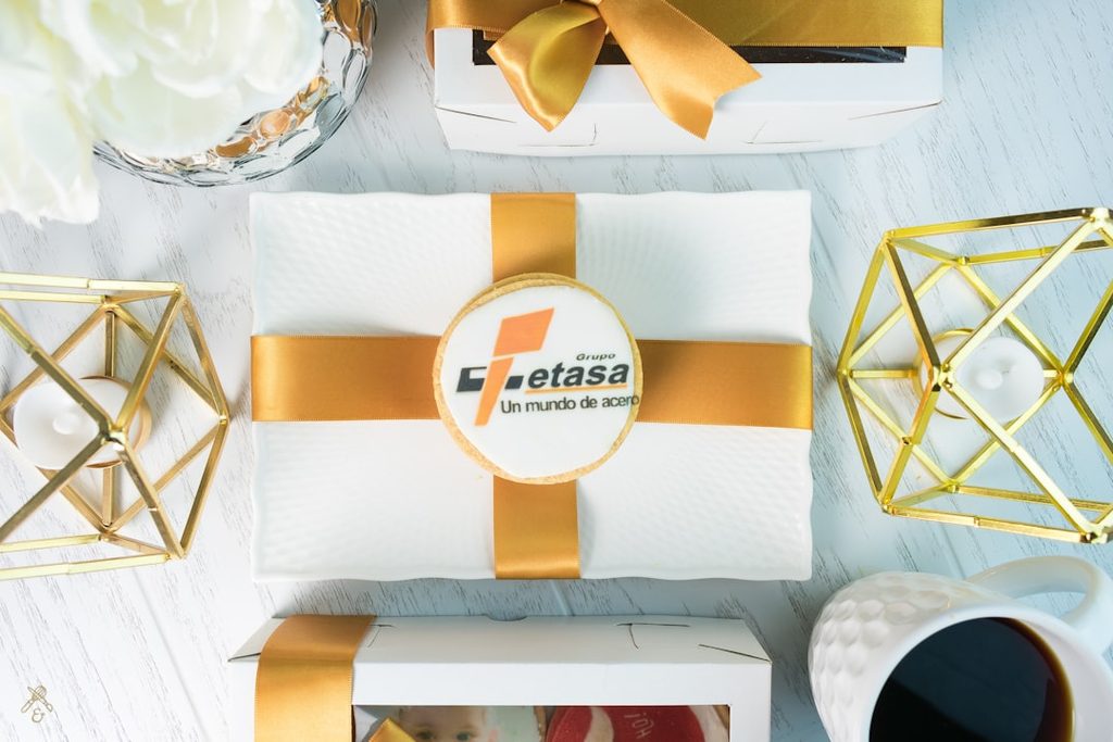 Paket kemasan putih dan emas yang menunjukkan pengalaman menerima produk premium dan layak dibagikan.