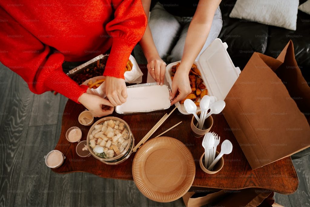 Packing food in eco-friendly materials on a wooden table.