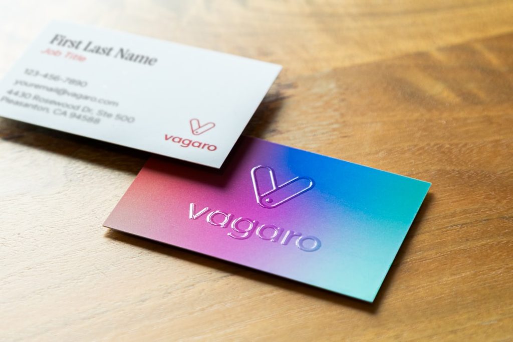 Kartu nama modern dengan warna holografik dan logo Vagaro.