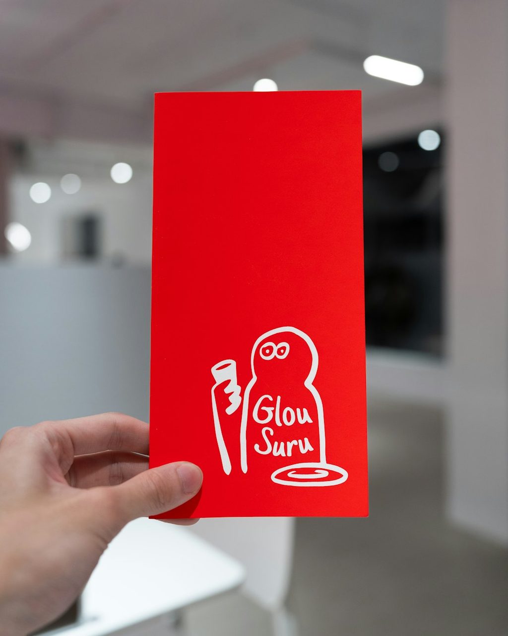 Kartu nama merah dengan desain lucu dan tulisan 'Glou Suru'.