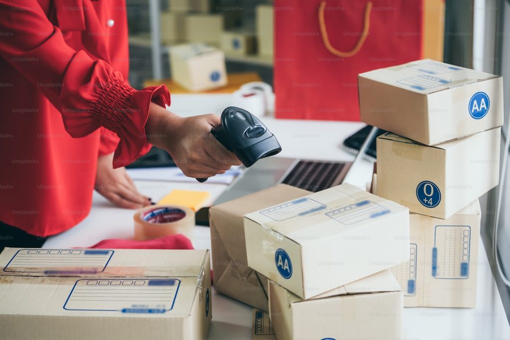 Pekerja memindai kode pada paket untuk pengecekan kualitas dan verifikasi sebelum distribusi