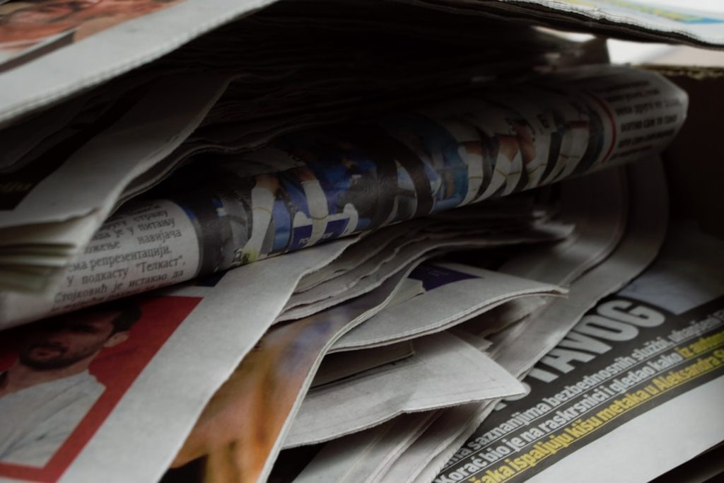 Close-up of stacked printed papers and magazines, showing different paper sizes and print formats relevant to flyer selection.