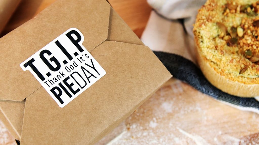 Stiker bertuliskan 'TGIP Thank God It's Pie Day' di atas kemasan kertas.