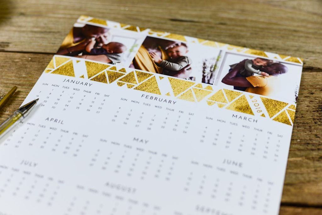 Desain kalender promosi meja dengan foto produk dan aksen emas untuk brand premium