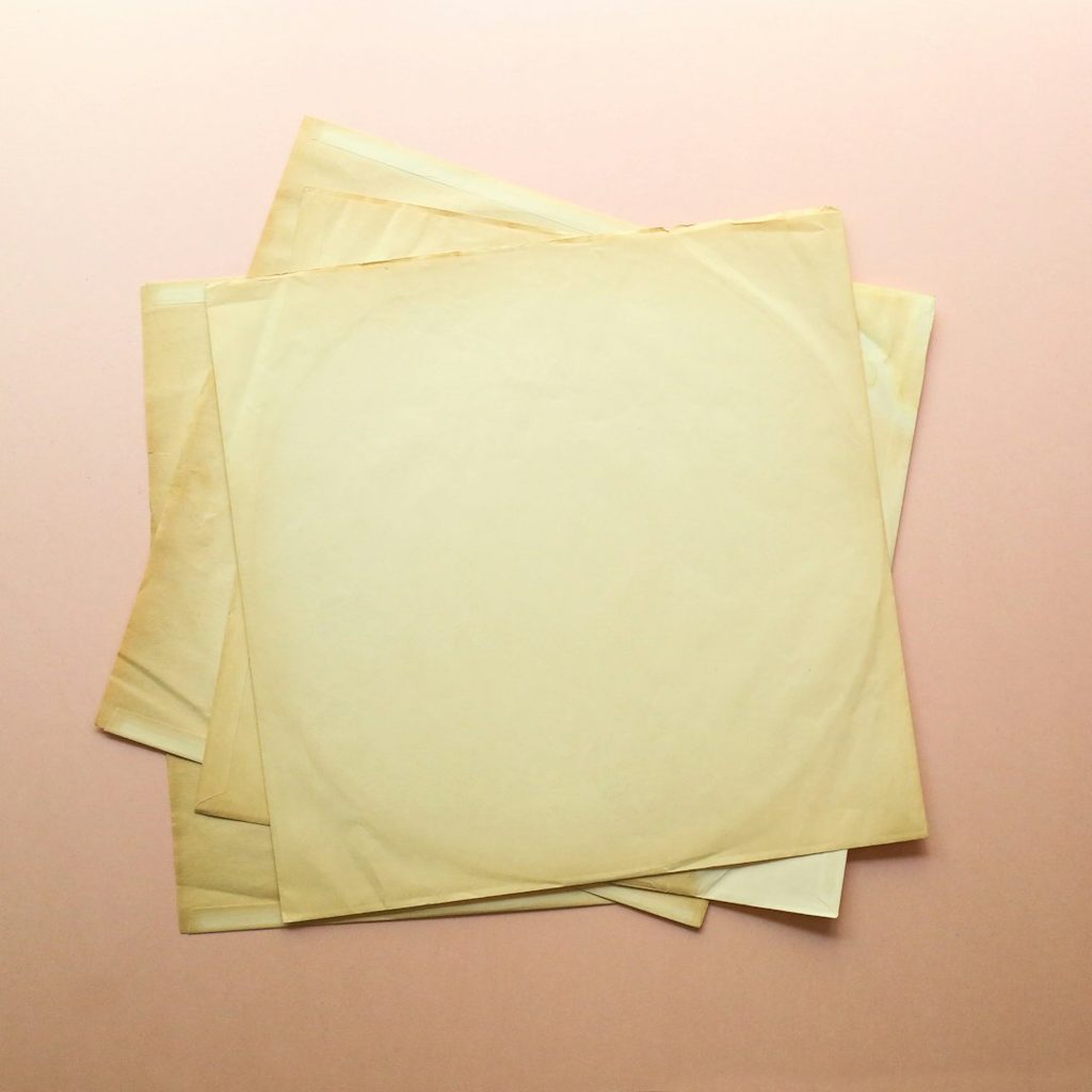 Gambarnya menunjukkan beberapa lembar kertas kuning yang rata dan bersih.