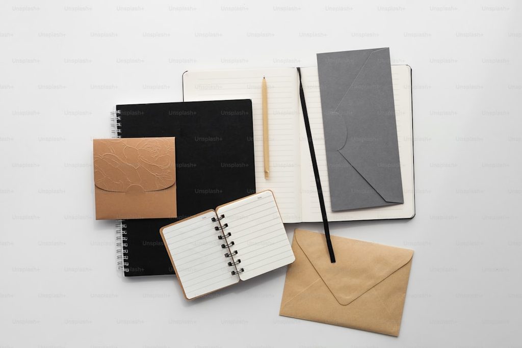 Buku, surat, dan envelope sebagai contoh materi cetak yang rapi dan mendukung kesan profesional brand.