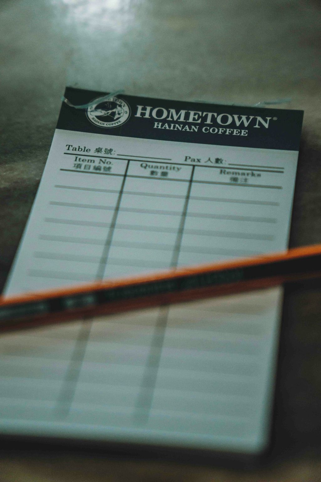 Nota pesanan Hometown Coffee dengan pulpen di meja.