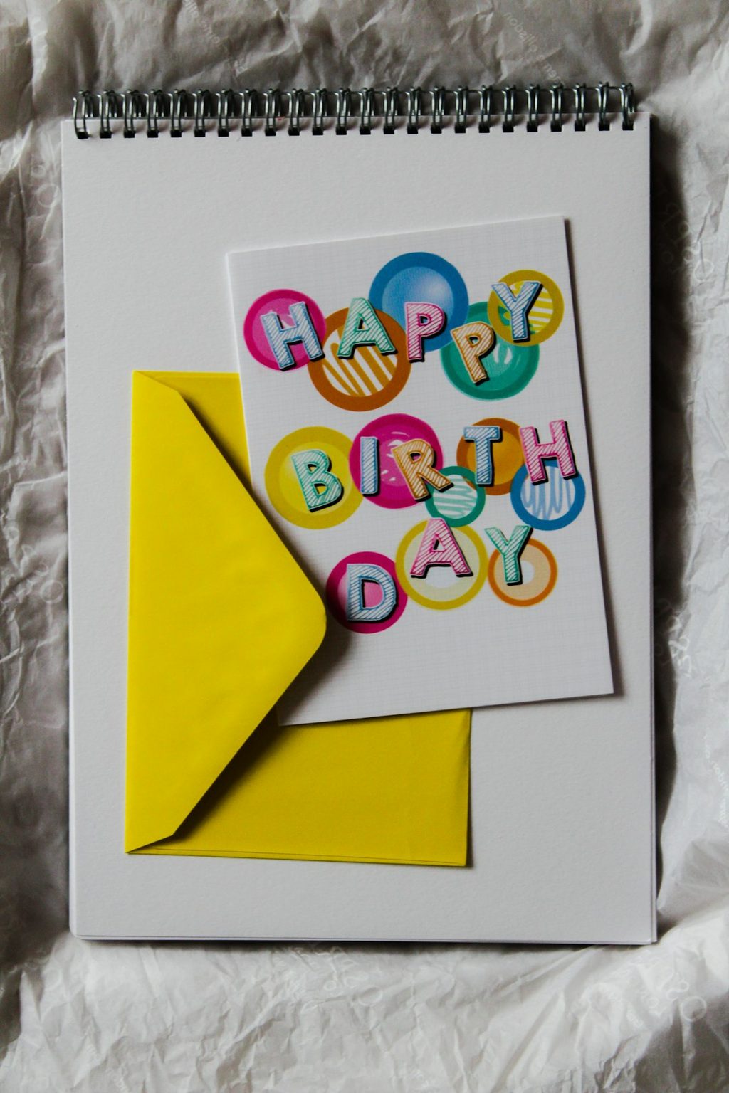 Kartu ulang tahun warna-warni dengan tulisan 'Happy Birthday' di atasnya.