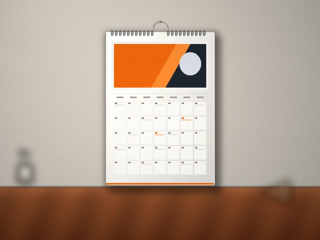 Order kalender dinding ukuran A4 jilid spiral terpasang rapi di dinding ruang kerja bisnis.