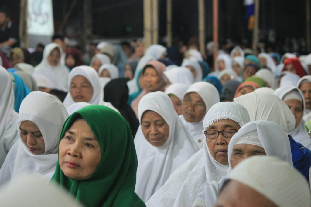 Foto bersama keluarga perempuan mengenakan hijab putih saat perayaan Lebaran