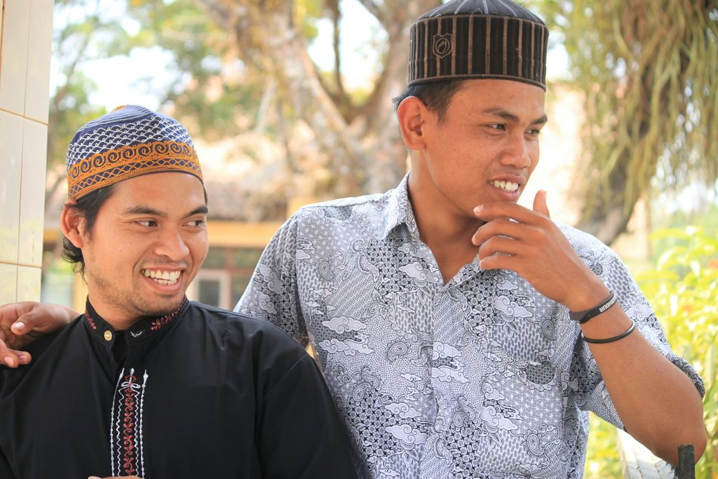 Dua orang pemilik usaha sedang berdiskusi memilih contoh bahan kertas dan warna cetakan untuk kemasan produk mereka