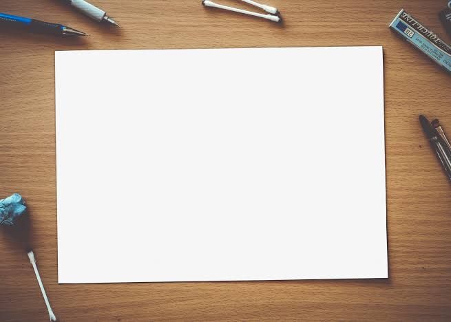 Kertas putih kosong di meja kerja dengan alat tulis
