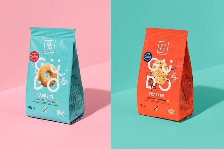 Paket makanan gluten free Guido dalam warna biru dan merah, di latar warna pastel.