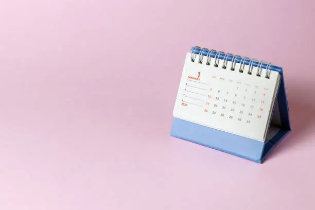 Kalender meja biru dengan lembaran bulan Januari dihiasi warna-warna cerah.