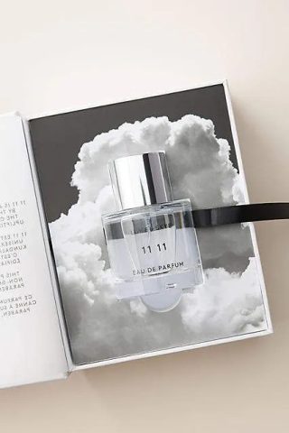 Botol parfum kaca bening dalam kotak dengan motif awan.