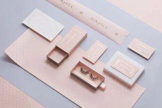 Kemasan kosmetik pastel dengan kotak matte dan pita cetak.