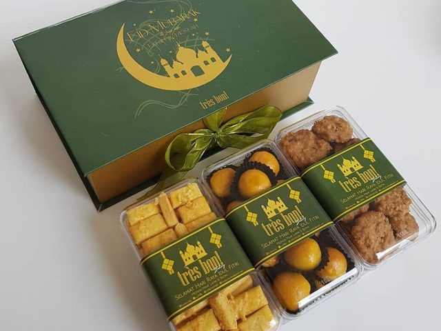 Kue tradisional dalam kotak hadiah berwarna hijau dengan tema Idul Fitri.
