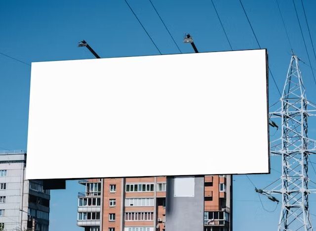 Billboard putih besar di depan bangunan apartemen
