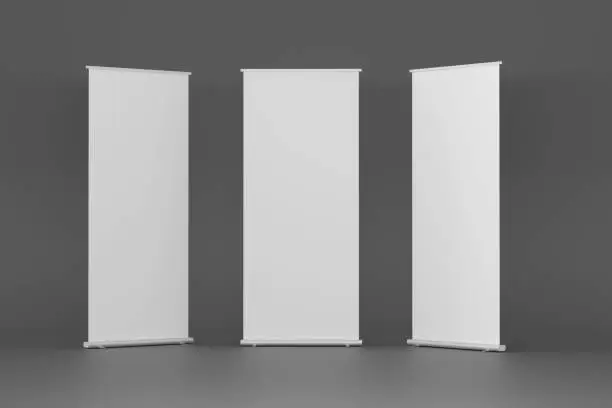 Tiga banner vertikal putih kosong di ruang minimalis