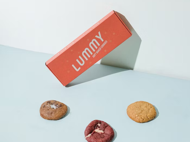Kue kering Lummy di depan kotak kemasan merah muda, produk Uprint.id.