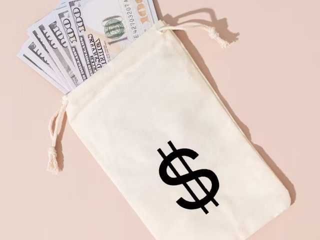 Dompet putih dengan simbol dolar dan uang kertas 100 dollar di dalamnya