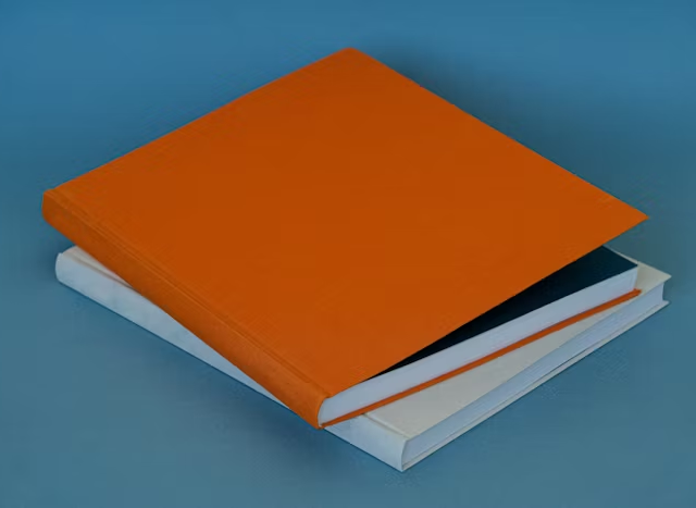 Buku hardcover dengan lembaran putih dan orange, ideal untuk desain profesional.