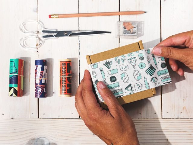 Tools for packaging and wrapping items on a wooden surface.